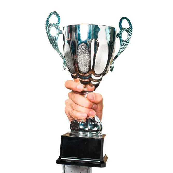 A person holding a trophy, symbolizing achievement and success in exams.